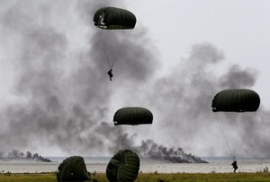 © Reuters. Indonesia soldiers jump with parachutes from a Hercules C-130 military transport plane during an exercise at Ranai military airbase