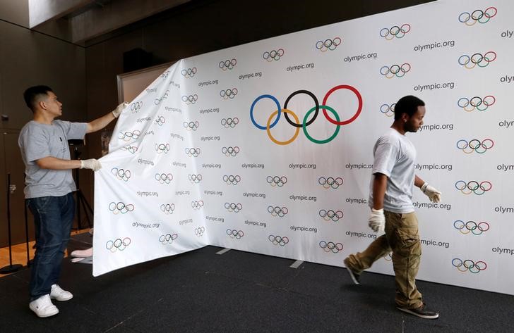 © Reuters. Staff of the IOC dismantle a backdrop after a news conference after the Olympic Summit on doping in Lausanne