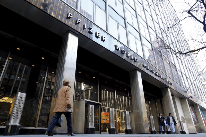 © Reuters. People pass by the Pfizer World Headquarters building in New York