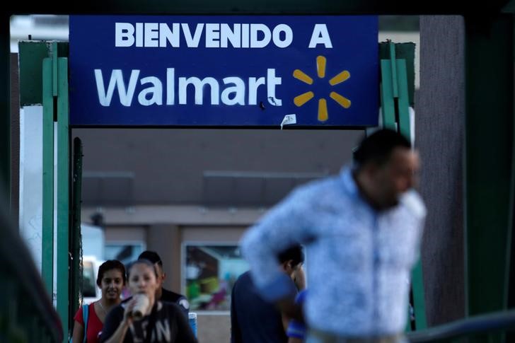© Reuters. People passes by a sign welcoming to a Wal-Mart store in Monterrey