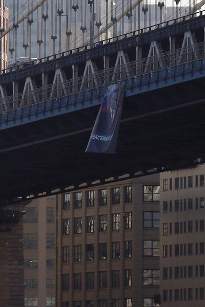 © Reuters. A banner with an image of Russian President Vladimir Putin hangs from the Manhattan Bridge in New York