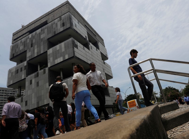 © Reuters. People walk next to the Petrobras headquarters in Rio de Janeiro