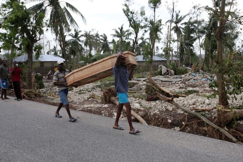 © Reuters. Men carry a coffin after Hurricane Matthew hit Cavaillon, Haiti