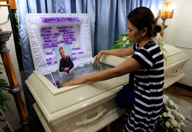 © Reuters. Zendey Celestino views the body of her husband Neptali Celestino, who was killed in a police anti-drugs operation in Pasig city, metro Manila