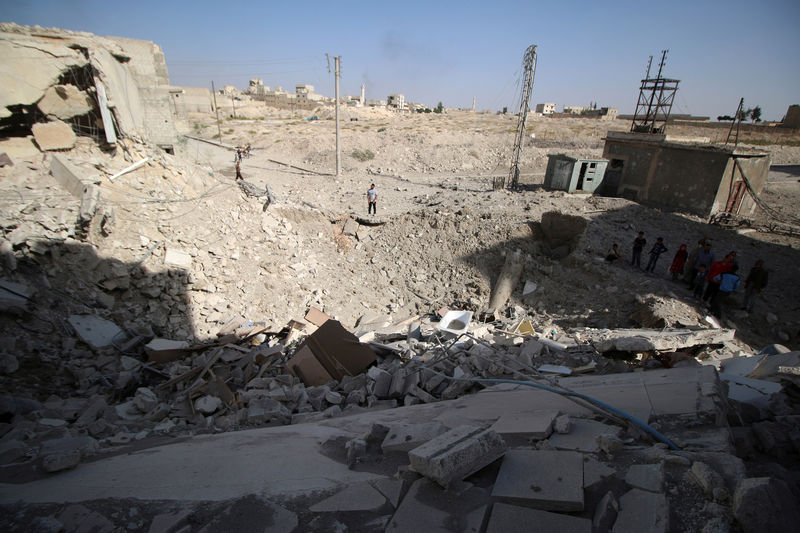 © Reuters. People inspect a damaged site after airstrikes in the rebel held Karam Houmid neighbourhood in Aleppo