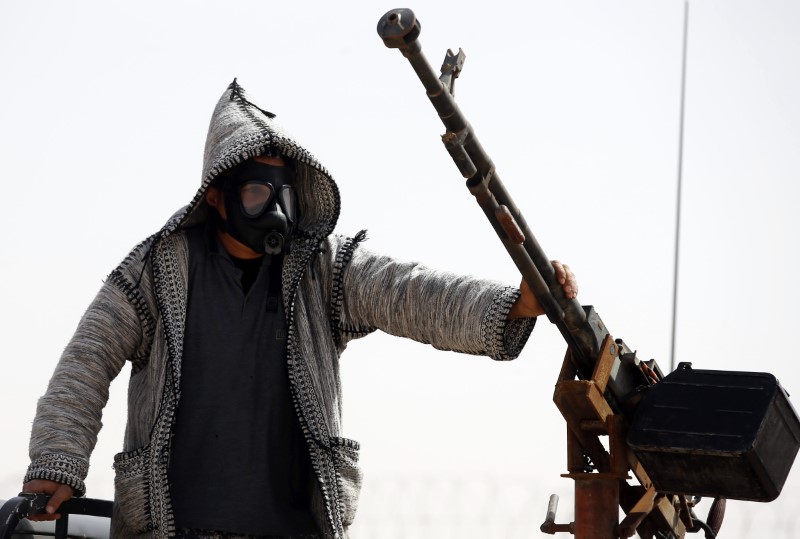 © Reuters. Fighter from Misrata wear a gas mask to protect his face from wind near Sirte