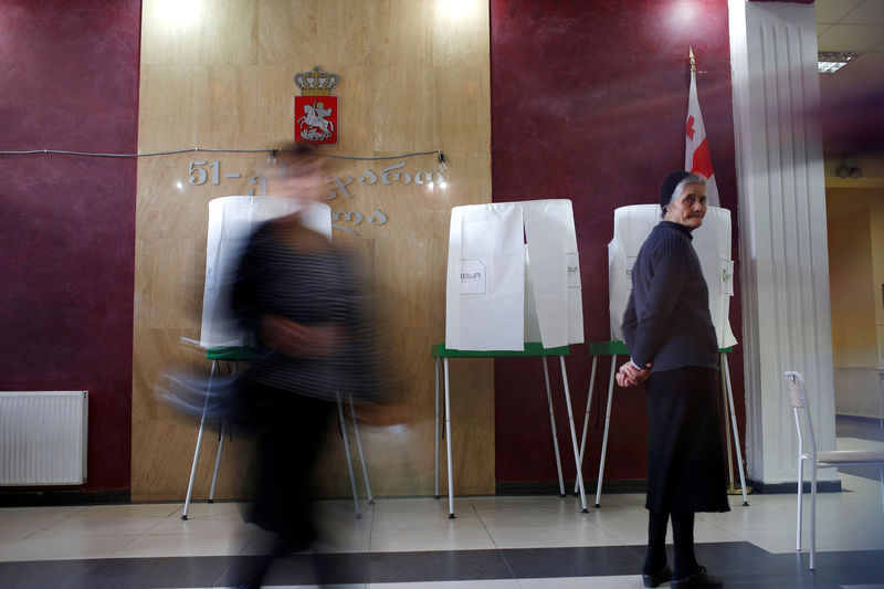 © Reuters. People walk at a polling station located in a public school ahead of the parliamentary elections in Tbilisi