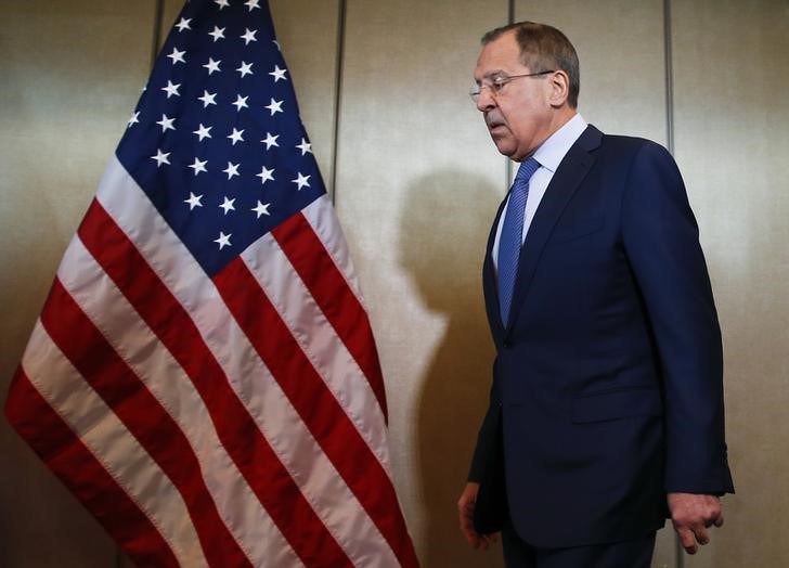 © Reuters. Russian Foreign Minister Lavrov walks past a U.S. flag before bilateral talks in Munich