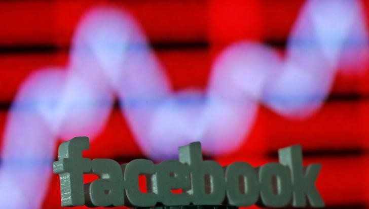 © Reuters. A 3D printed Facebook logo is seen in front of a displayed stock graph in this illustration taken