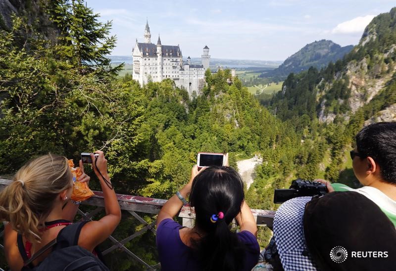 © Reuters. Tourists take pictures at the south Bavarian Neuschwanstein castle near Schwangau