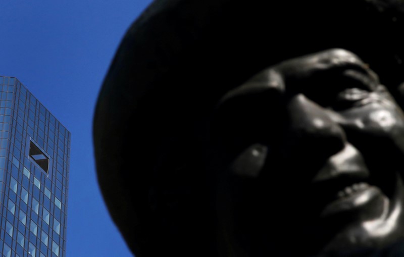 © Reuters. Germany's Deutsche Bank headquarters are seen next to the sculpture of a smiling man in Frankfurt