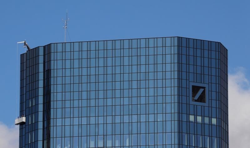 © Reuters. Window cleaners are working on the facade of the headquarters of Germany's Deutsche Bank in Frankfurt