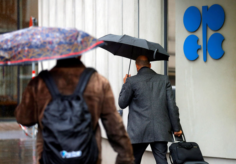 © Reuters. People carrying umbrellas walk by the OPEC headquarters in Vienna