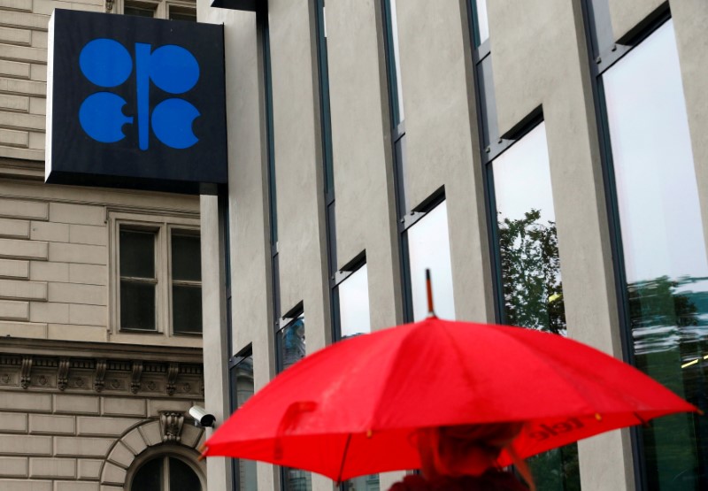 © Reuters. A person carrying an umbrella walks by the OPEC headquarters in Vienna