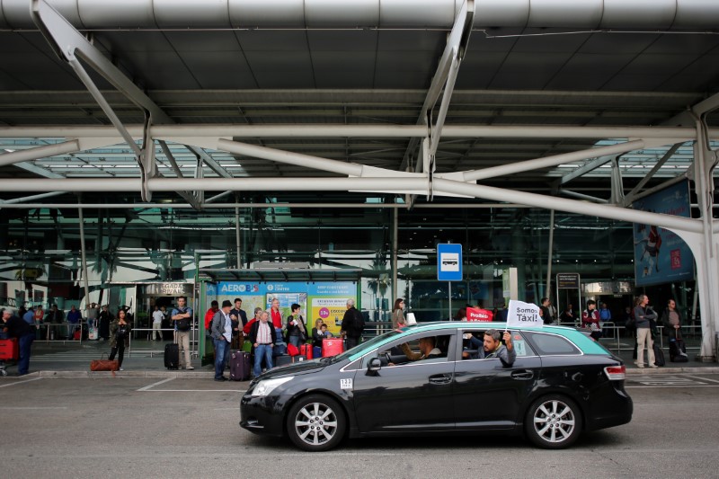 © Reuters. A Taxi driver passes by tourists at a bus stop in Lisbon Airport during Taxi drivers protest against Uber Technologies Inc. in Lisbon