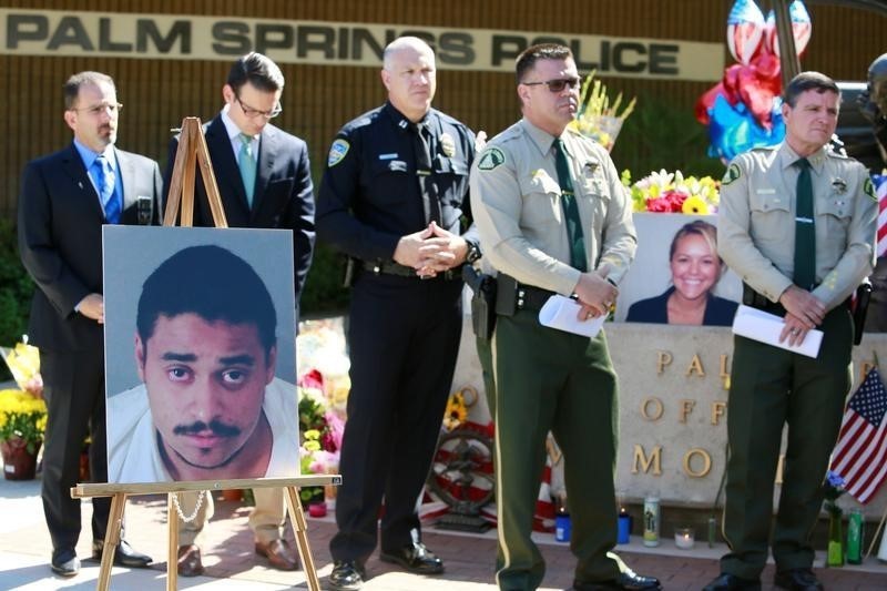 © Reuters. A photograph of suspect John Felix is displayed at a news conference near photo of slain officer Zerebny in Palm Springs, California