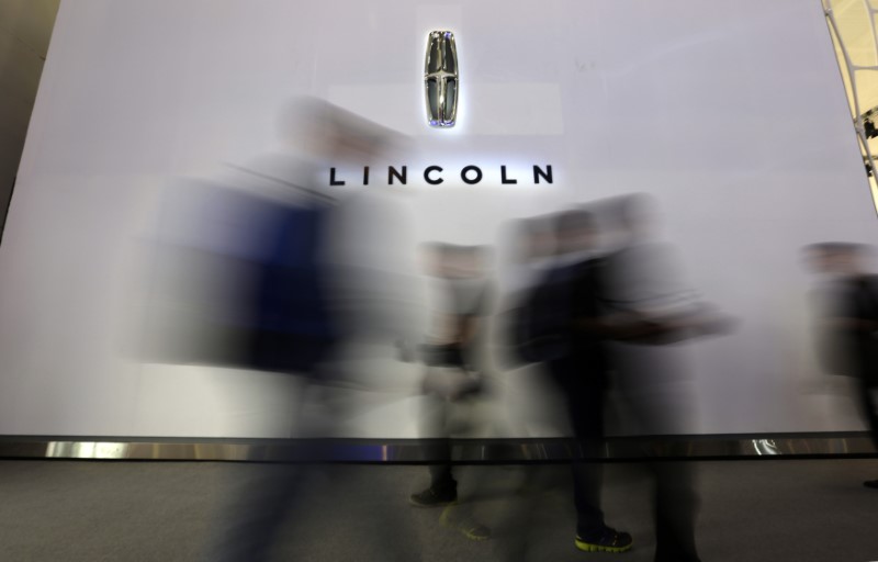© Reuters. Visitors walk past a logo of Lincoln at Auto China 2014 in Beijing