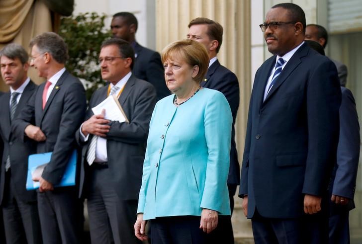 © Reuters. Ethiopian Prime Minister Desalegn and German Chancellor Merkel listen to national anthems at the National Palace in Addis Ababa