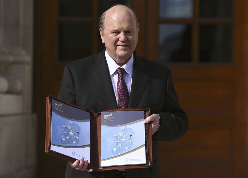 © Reuters. Ireland's Minister for Finance Michael Noonan displays a copy of the budget on the steps of Government Buildings in Dublin