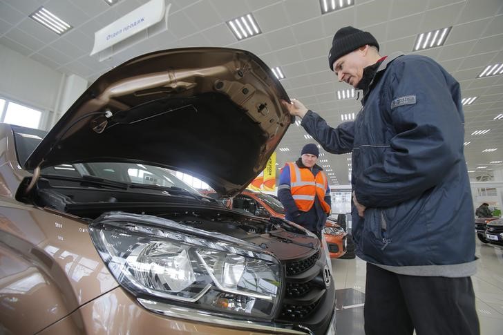 © Reuters. Покупатель изучает автомобиль Лада в дилерском магазине Автоваза в Москве