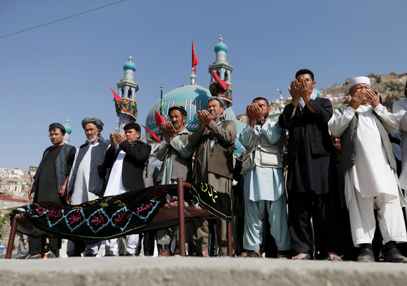 © Reuters. Afghan Shi'ite Muslims perform prayers at the funeral for one of the victims of Tuesday's attack at the Sakhi Shrine in Kabul, Afghanistan