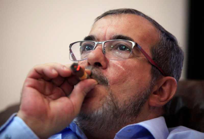 © Reuters. FARC rebel leader Rodrigo Londono smokes a Cohiba cigar while watching a live transmission of the referendum on a peace deal, in Havana, Cuba