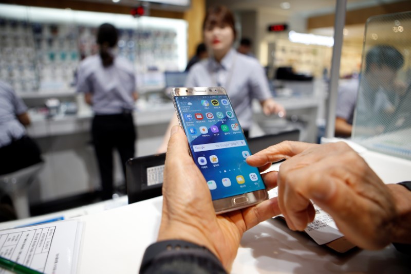 © Reuters. A customer uses his Samsung Electronics' Galaxy Note 7 as he waits for exchange at company's headquarters in Seoul