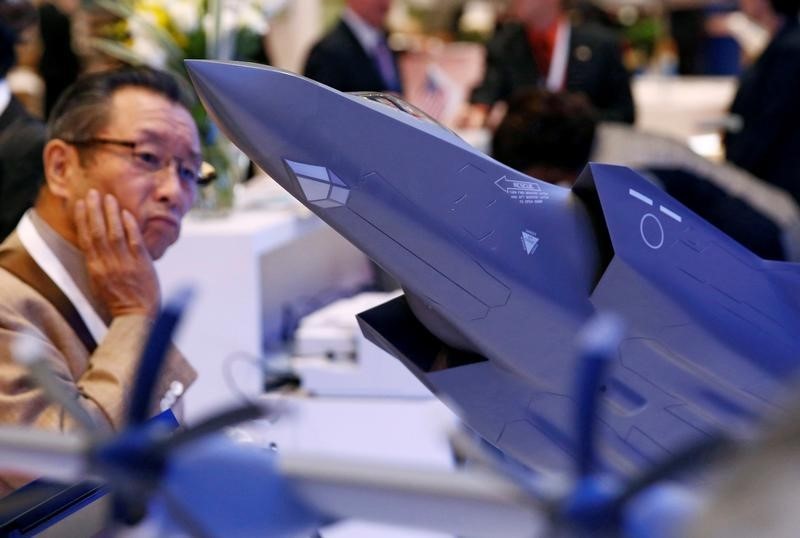 © Reuters. A man looks at a model of Lockheed Martin's F-35 fighter jet during Japan Aerospace 2016 air show in Tokyo