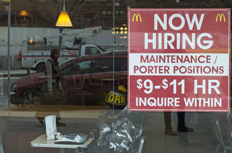 © Reuters. A diner sits next to a help wanted sign at a McDonalds restaurant in the Brooklyn borough of New York