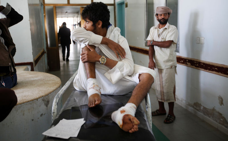 © Reuters. A man injured by Saturday's apparent Saudi-led air strike on a community hall sits on a hospital bed in the capital Sanaa, Yemen