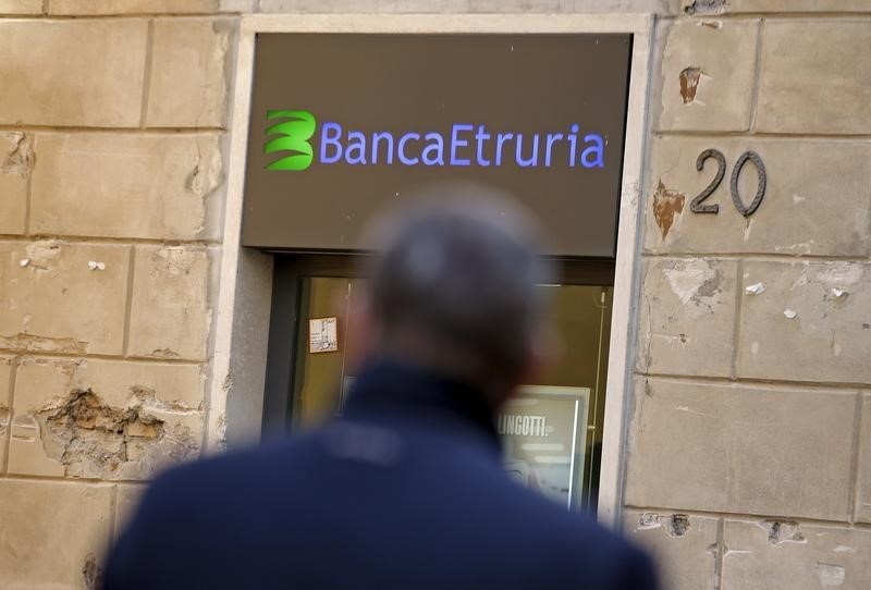 © Reuters. A man walks in front of Banca Etruria in downtown Rome