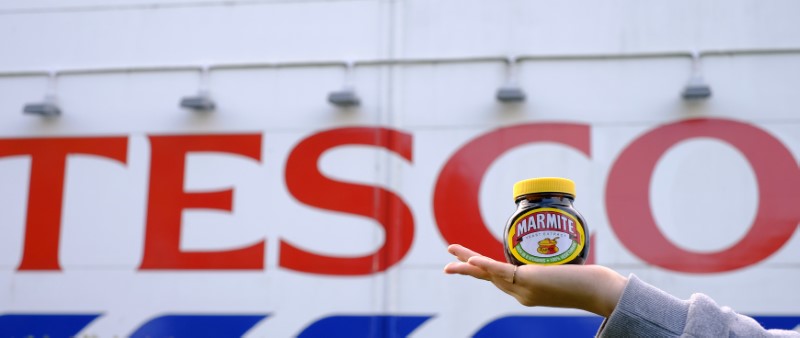 © Reuters. A woman poses with a jar of Marmite outside a Tesco store near Manchester