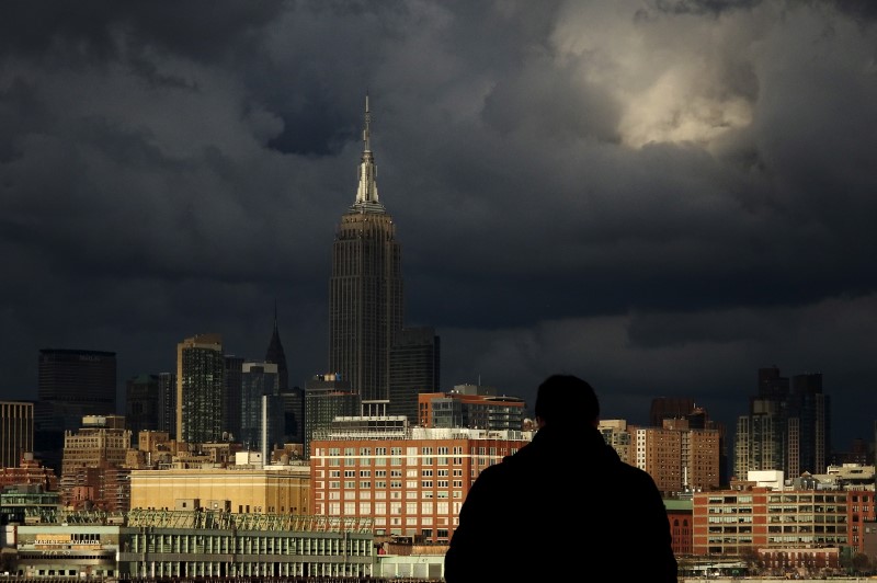 © Reuters. A man is seen in front of the skyline of New York's Mid Town Manhattan