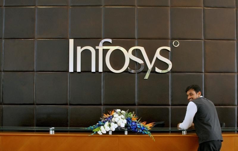 © Reuters. An employee of Infosys stands at the front desk of its headquarters in Bengaluru