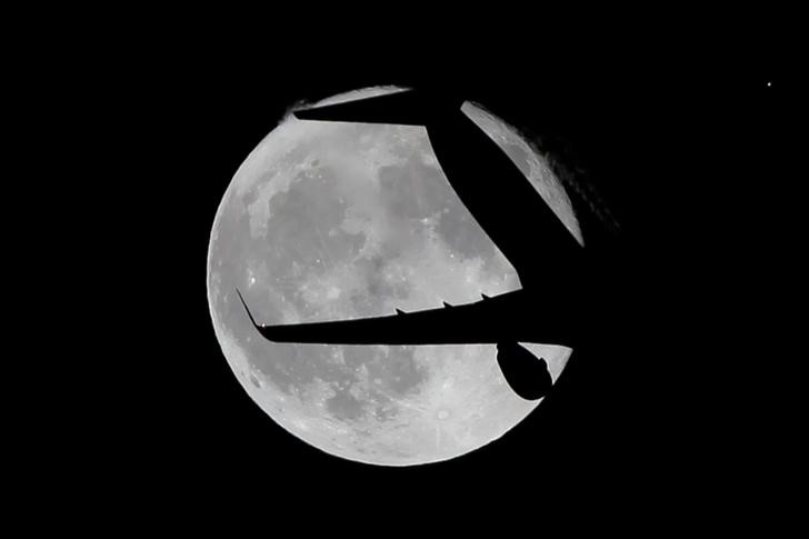 © Reuters. A Ryanair passenger aircraft flies past a super moon in Ardales