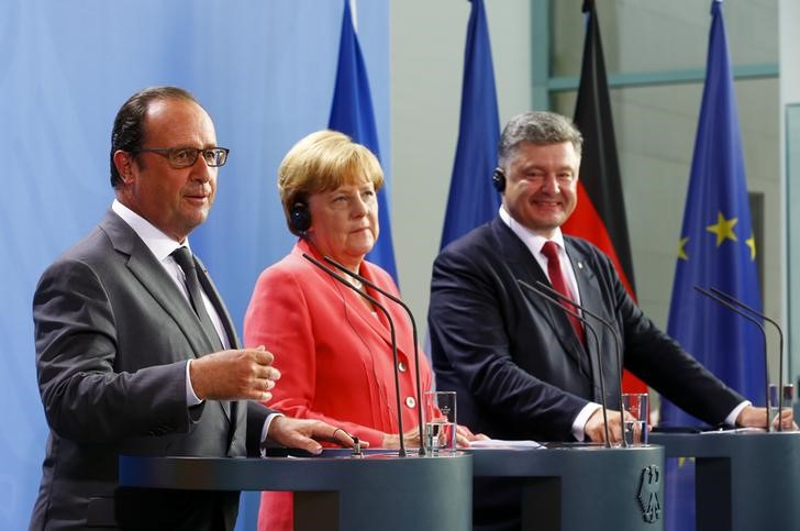 © Reuters. Ангела Меркель, Франсуа Олланд и Петр Порошенко говорят с репортерами после встречи в Берлине