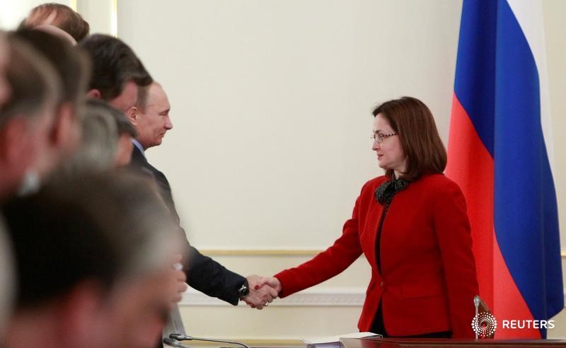 © Reuters. Глава Банка России Эльвира Набиуллина (справа) и президент РФ Владимир Путин жмут руки на встрече в Ново-Огарёво