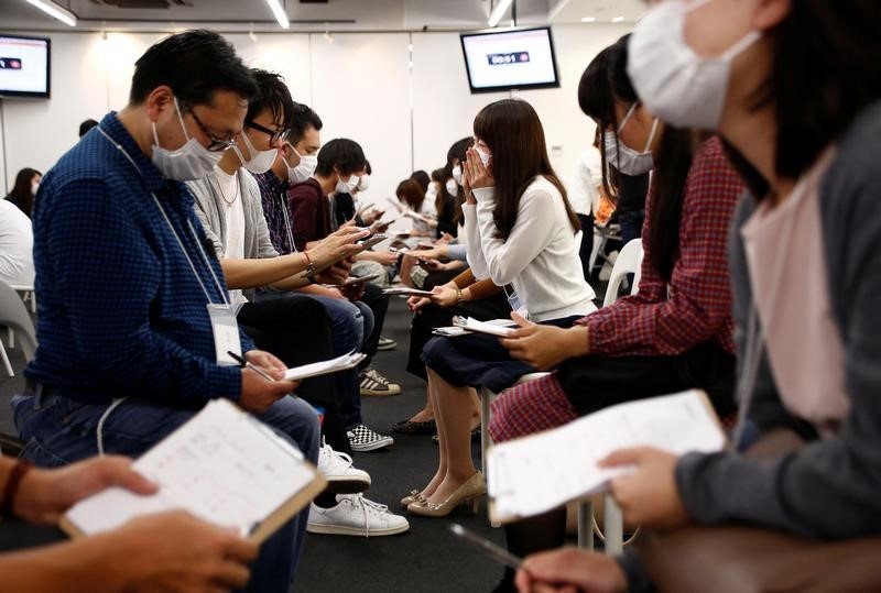 © Reuters. اليابانيون يرتدون كمامات طبية في جلسات المواعدة السريعة