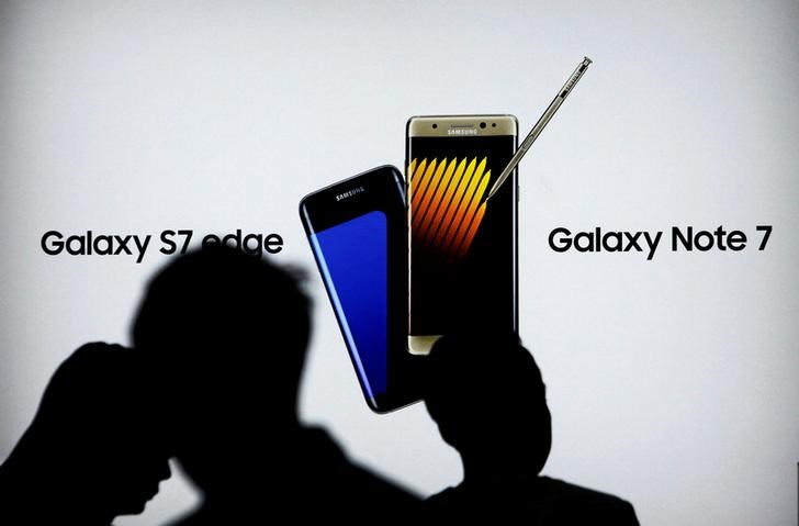 © Reuters. Shoppers walk near a Galaxy Note 7 advertisement at a Samsung store in Jakarta