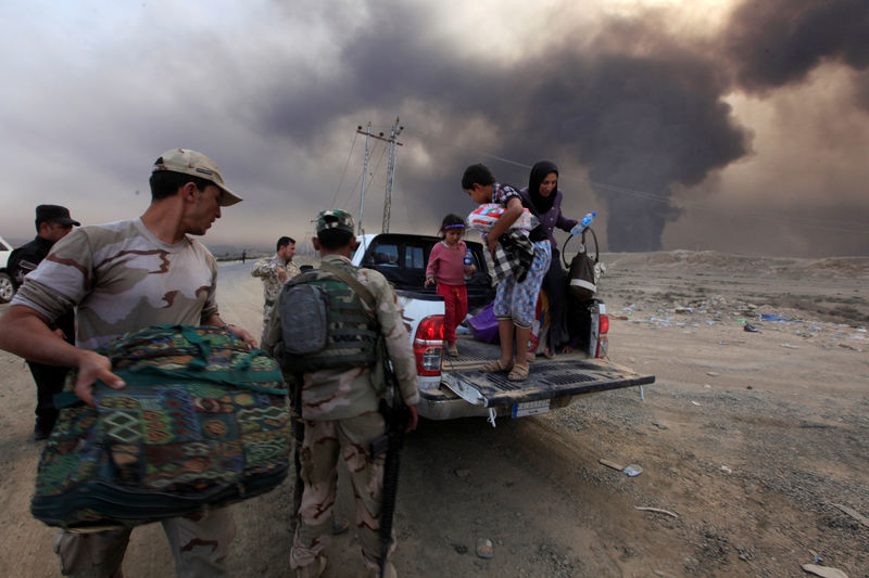 © Reuters. Pessoas fogem de conflito em Qayyarah durante operação para resgatar Mosul