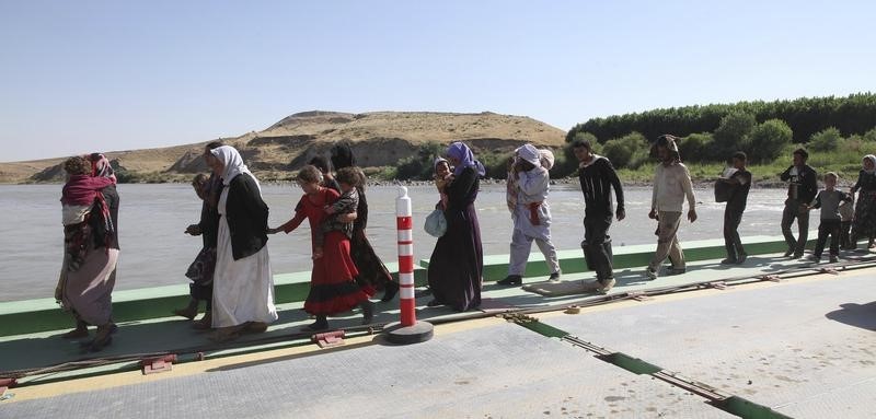 © Reuters. Displaced people from the minority Yazidi sect, fleeing the violence in the Iraqi town of Sinjar, re-enter Iraq from Syria at the Iraqi-Syrian border crossing in Fishkhabour, Dohuk Province