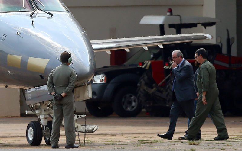 © Reuters. Former speaker of Brazil's Lower House of Congress, Eduardo Cunha, is escorted by federal police during their transfer to Curitiba, in the hangar of the Federal Police in Brasilia