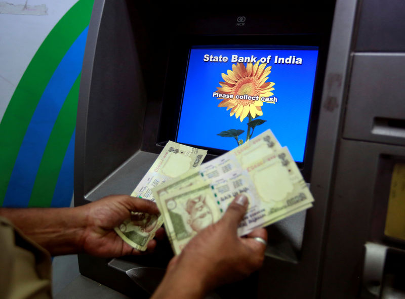 © Reuters. File photo of a man counting money after withdrawing it from a State Bank of India ATM in Mumbai