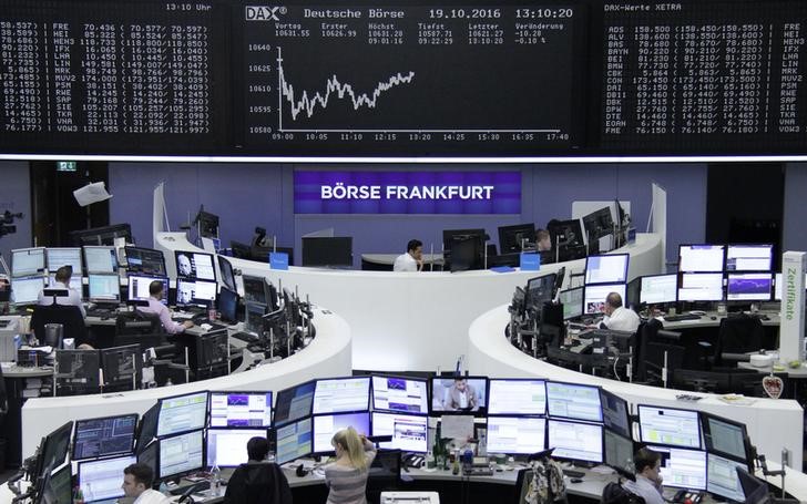 © Reuters. Traders work at their desks in front of the German share price index, DAX board, at the stock exchange in Frankfurt