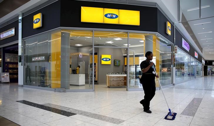 © Reuters. A worker sweeps past an outlet of South Africa's MTN Group in Johannesburg