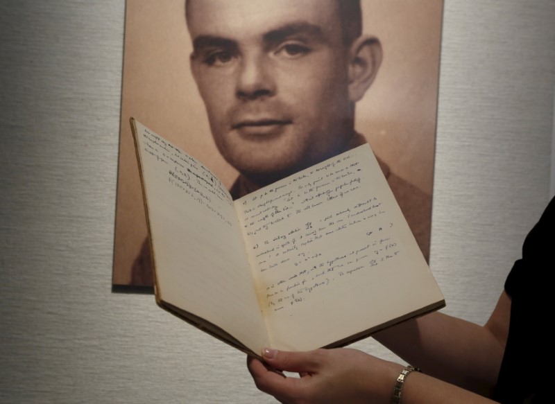 © Reuters. Notebook of British mathematician and pioneer in computer science Alan Turing is displayed in front of a photo of him during an auction preview in Hong Kong