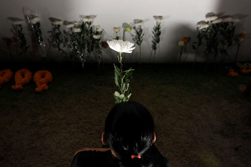 © Reuters. A mourner pays her respects to the late King Bhumibol Adulyadej along the Grand Palace walls in Bangkok