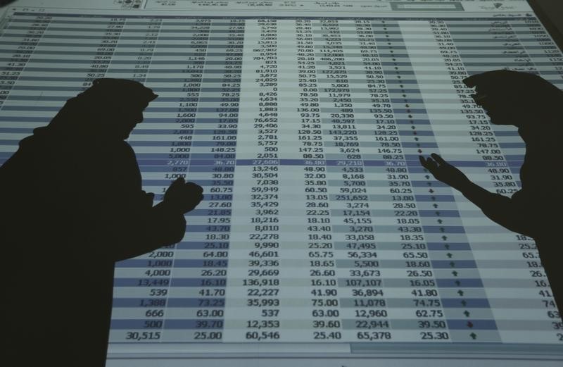 © Reuters. The shadows of investors and speculators are seen cast on a screen as they monitor stock prices at the FALCOM investment bank in Riyadh