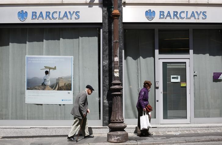 © Reuters. A couple walks past a Barclays branch in downtown Rome