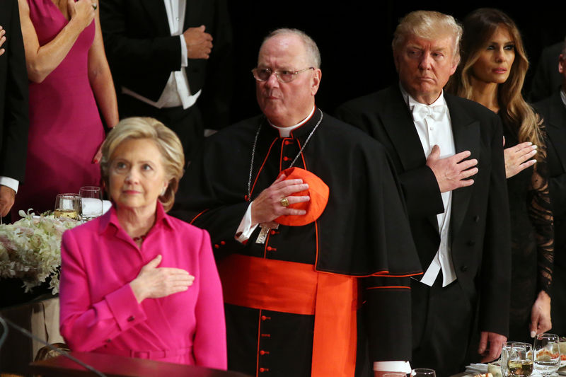 © Reuters. Republican U.S. presidential nominee Donald Trump looks at Democratic U.S. presidential nominee Hillary Clinton during the national anthem as they attend the Alfred E. Smith Memorial Foundation dinner to benefit Catholic charities in New York, U.S.